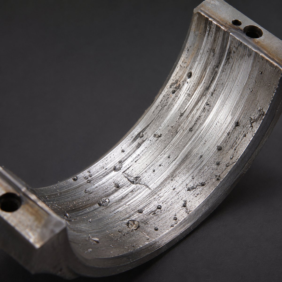 Bearing showing contamination damage — embedded particles and circumferential scoring